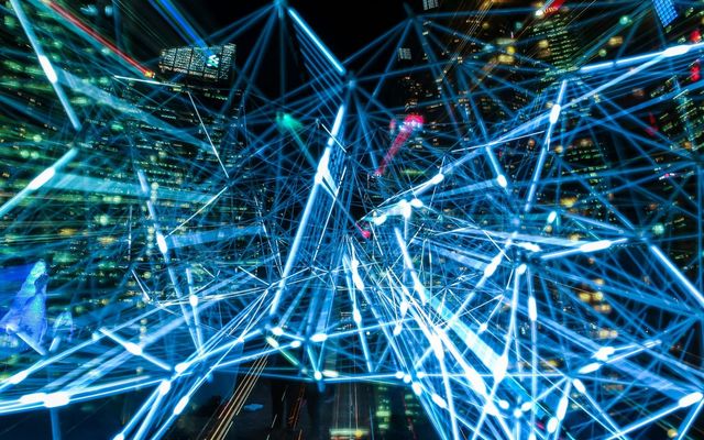 Dynamic urban scene showcasing interconnected light trails representing digital communication networks.