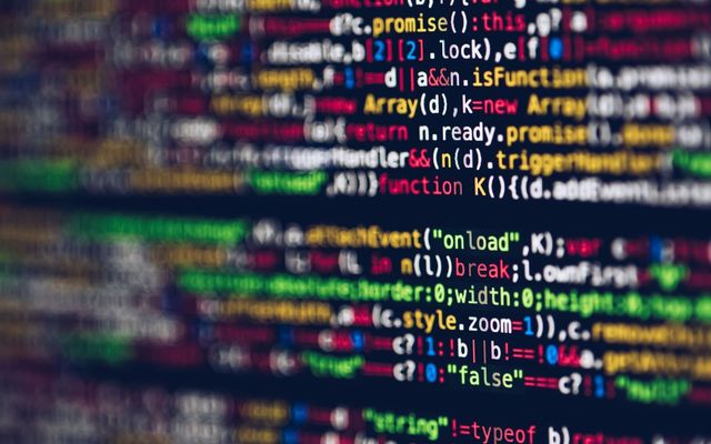 Vivid, blurred close-up of colorful code on a screen, representing web development and programming.